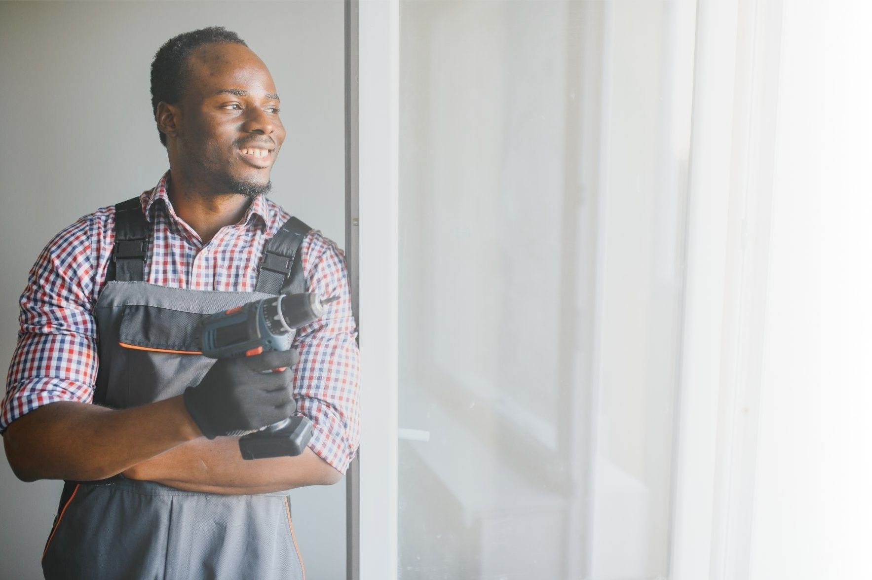Young African repairman holding a drill Handyman Services